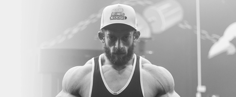 Growth Supplements - atleta masculino de boné treinando em máquina na academia