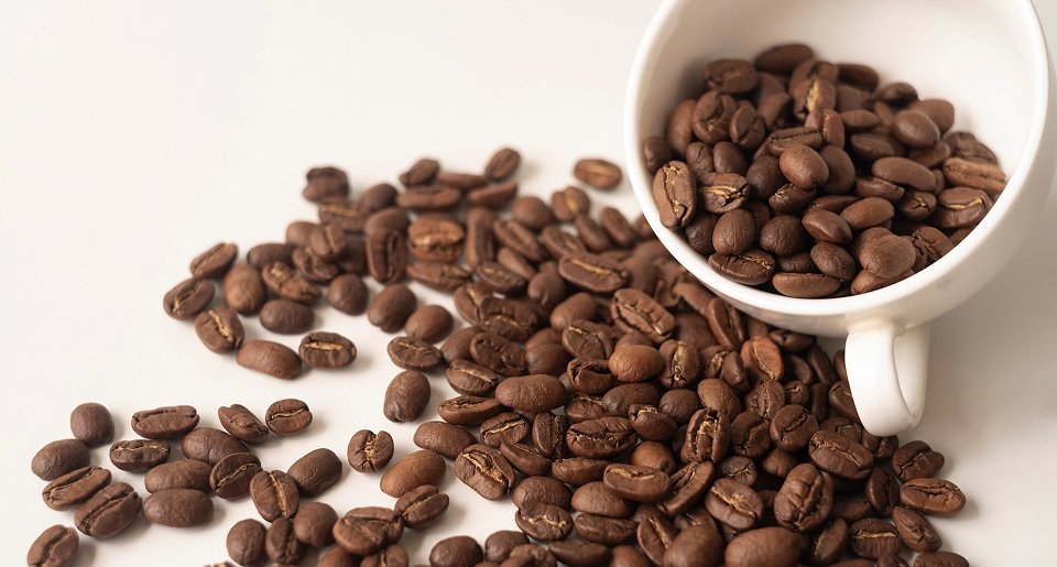 Uma xicara de café, com grãos ao redor
