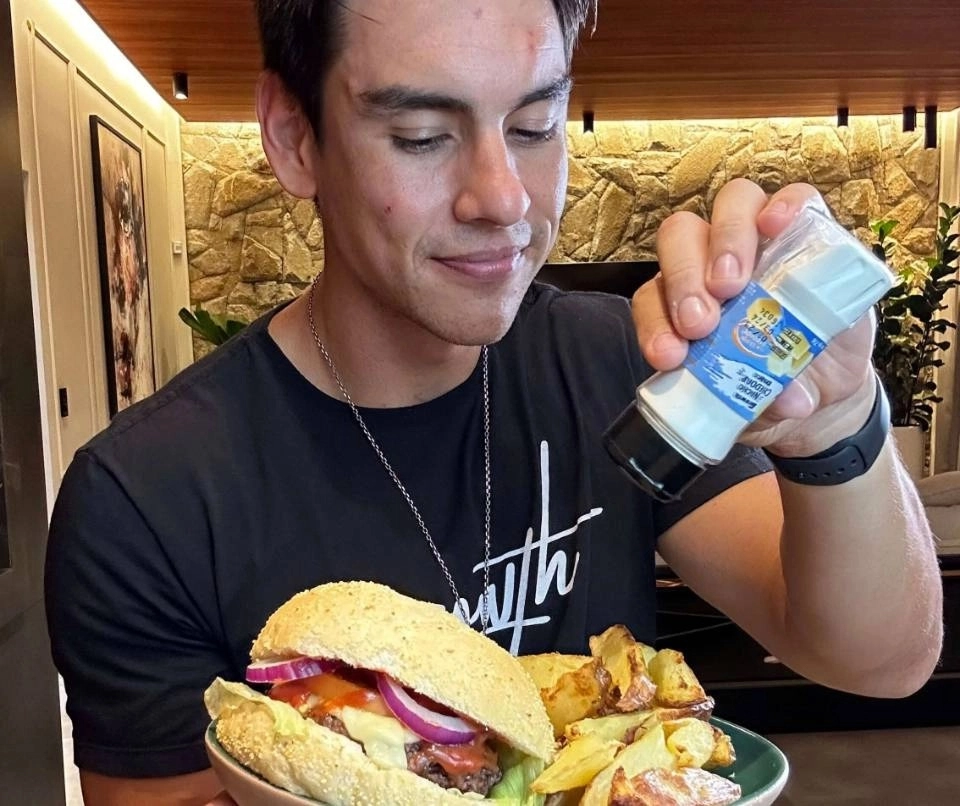 Gabriel Arones temperando um lanche com batatas fritas