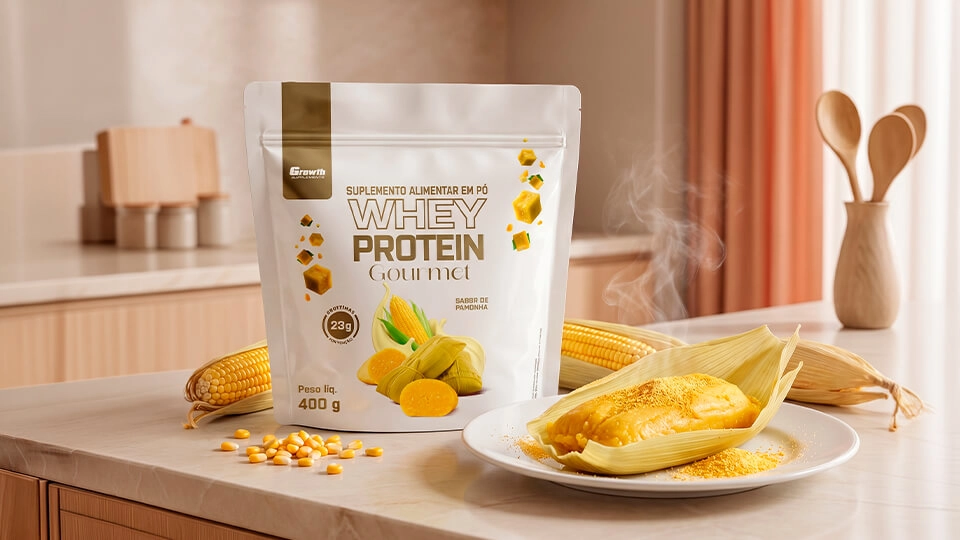 GROWTH SUPPLEMENTS - Embalagem de Whey Gourmet Pamonha no balcão de uma cozinha com milho no prato
